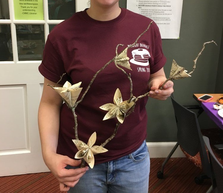 A student showing off their final craft project